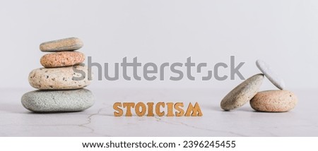 Concept stoicism word made from letters and pyramid of stones on gray background web banner