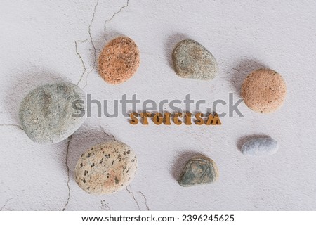 Concept stoicism word made from letters and stones around on a gray background top view