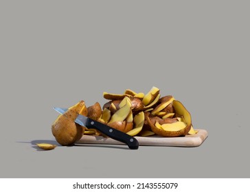 Concept Of Stop Food Waste Day. Potato Peels Are One Of The Most Commonly Discarded Items During Food Prep. Gray Background.