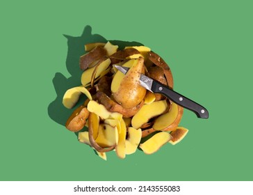 Concept Of Stop Food Waste Day. Potato Peels Are One Of The Most Commonly Discarded Items During Food Prep. Green Background.