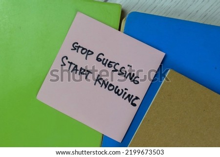 Concept of Stop Guessing, Start Knowing write on a book isolated on Wooden Table. Selective focus on Stop guessing, start knowing text