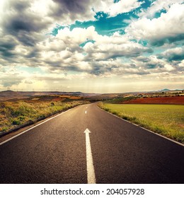 Concept of straight way for business and new career start. Asphalt road over cloudscape background. 