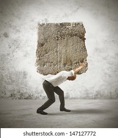 Concept of stress of a businessman with a big rock