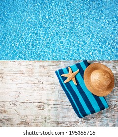 Concept of summer accessories on wood with blue water as background