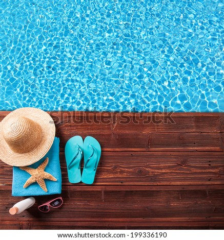 Concept of summer accessories on wood with blue water