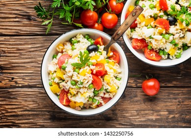 concept of summer food with Cold rice salad, tuna, green pea and tomato, rustic style and selective focus