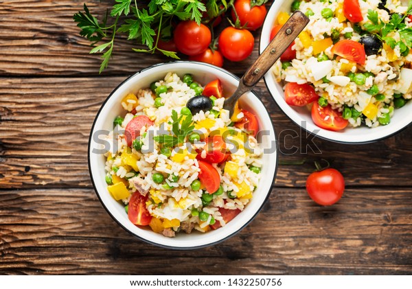 concept of summer food\
with Cold rice salad, tuna, green pea and tomato, rustic style and\
selective focus