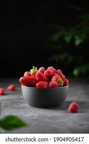 Concept of summer food with strawberry and raspberry on a dark background, selective focus image