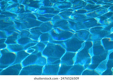 Concept - summer, leisure, lifestyle. Swimming pool surface with light ripple patterns and reflections. Blue ceramic tiled floor.  - Powered by Shutterstock