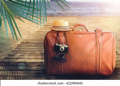 Concept Of Summer Traveling With Old Suitcase On Blur Beach Background.