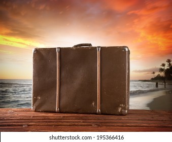 Concept of summer travelling with old suitcase. Blur beach on background