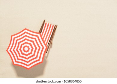 The concept of summer vacation. Top view on a sun lounger under an umbrella on the sandy beach