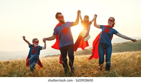 Concept Of Super Family, Family Of Superheroes At Sunset In Nature
