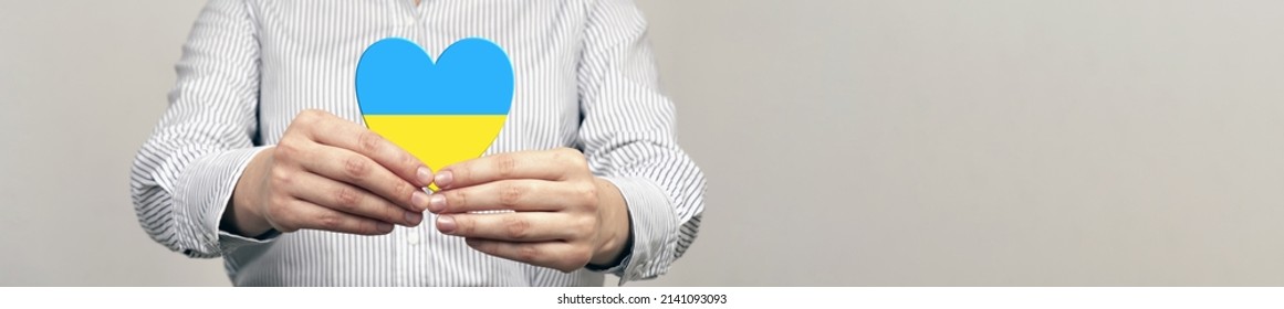 The concept of support Ukraine. heart in the colors of the flag of Ukraine in female hands. - Powered by Shutterstock