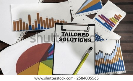 Concept of Tailored Solutions write on paperwork isolated on Wooden Table.