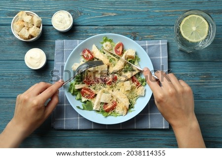 Concept of tasty eating with Caesar salad on wooden table