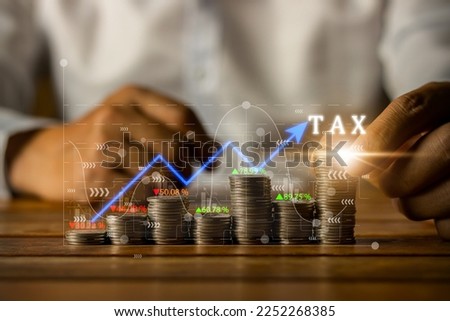 Concept of tax deduction planning, expenses, accounting, VAT, income tax, foreign tax filing in the country. and property and land taxes. Paying taxes. Hands of businessman and coins on wooden table.
