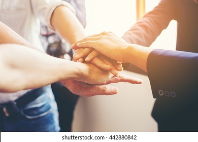  Concept of teamwork: Close-Up of hands business team showing unity with putting their hands together.
