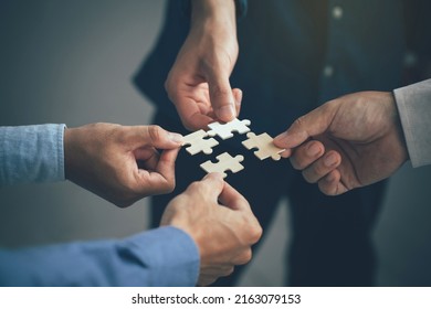 Concept of teamwork and partnership. Hands join puzzle pieces in the office. business people putting the jigsaws team together.Charity, volunteer. Unity, team business. - Shutterstock ID 2163079153