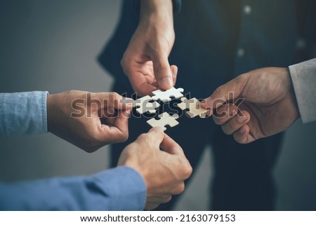 Concept of teamwork and partnership. Hands join puzzle pieces in the office. business people putting the jigsaws team together.Charity, volunteer. Unity, team business. ストックフォト © 