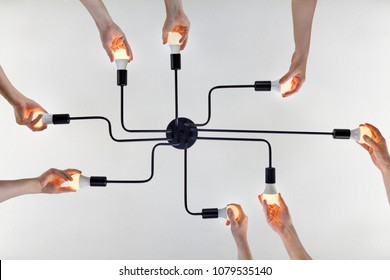 Concept Of Teamwork, Or Shared Purpose On Example Of United Actions When Replacing LED Lamps In A Ceiling Lighting.