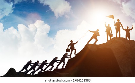 Concept Of Teamwork With Team Climbing Mountain Top