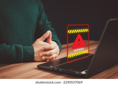 Concept technology of computer virus detected, personal data protection, network security and maintenance. Man using a computer laptop with triangle caution warning sign for notification error.