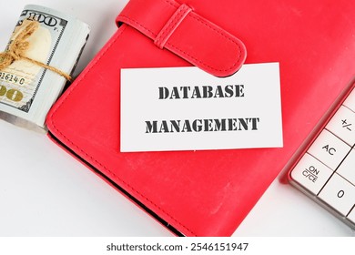 The concept of technology and development. Phrase, words, text DATABASE MANAGEMENT on a white business card on the background of a red notebook.