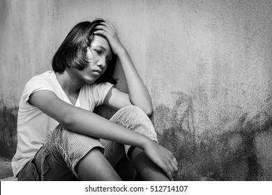 Concept teen problem, sad girl sitting alone black and white tone