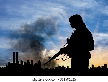 Concept of terrorism. Silhouette terrorist on city background in smoke