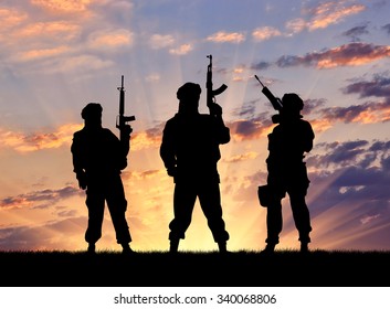 Concept Of A Terrorist. Silhouette Terrorists With Rifle At Sunset