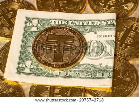 Concept of Tether coin against gold bitcoin coins and a single US dollar note or bill. Tether is backed by US dollar and used for trading in alt coins