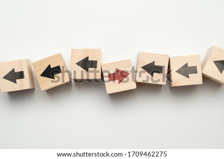 Concept of think differently - wooden cubes with arrows. Close up.