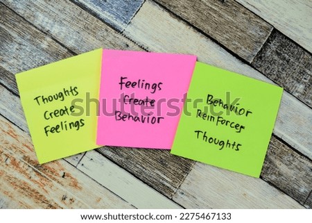 Concept of Thoughts Create Feeling - Feelings Create Behavior - Behavior Reinforce Thoughts circle write on sticky notes isolated on Wooden Table.