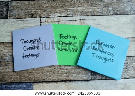 Concept of Thoughts Create Feelings - Feelings Create Behavior - Behavior Reinforces Thougts write on sticky notes isolated on Wooden Table.