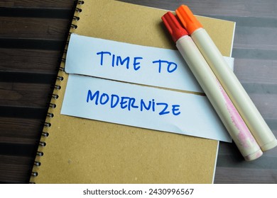 Concept of Time To Modernize write on sticky notes isolated on Wooden Table.