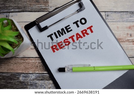 Concept of Time to restart write on clipboard isolated on Wooden Table.