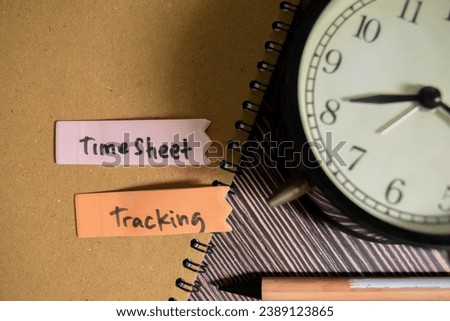 Concept of TimeSheet Tracking write on sticky notes isolated on Wooden Table.