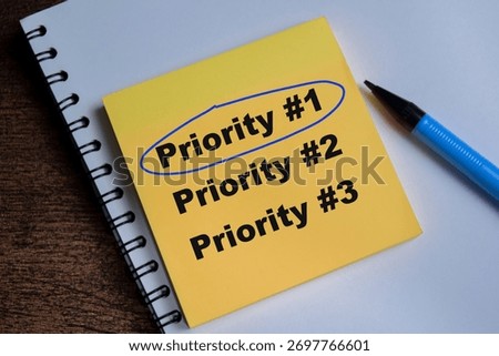 Concept of top priority write on sticky notes isolated on Wooden Table.