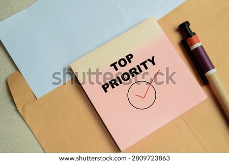 Concept of top priority write on sticky notes isolated on Wooden Table.