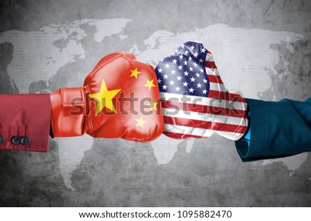 Concept of trade war between USA and China. Two hands of wearing boxing gloves with China and USA flag over world map