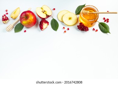 Concept of traditional Jewish holiday of Rosh Hashanah. New Year. Pomegranates, honey and apples on a white background. Place for your text.