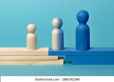 Concept of transition from child to adolescent to adult. 
Wooden figures on blue background - Shutterstock ID 1886782348