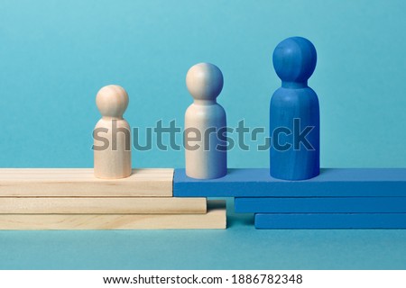 Concept of transition from child to adolescent to adult. 
Wooden figures on blue background Stockfoto © 