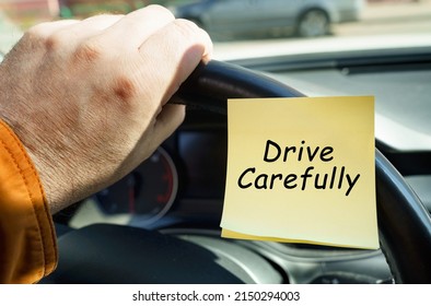 The concept of transport security. A man holds on to the steering wheel, next to a sticker with the inscription - Drive Carefully