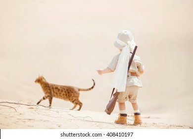 Concept Of Travel And Fascinating Adventures. Hild In Suit Of Treasures Seeker Like Indiana Jones In The Desert Whit Wild Cat Similar To Tiger