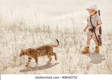 Concept Of Travel And Fascinating Adventures. Hild In Suit Of Treasures Seeker Like Indiana Jones In The Desert Whit Wild Cat Similar To Tiger