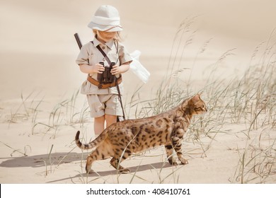 Concept Of Travel And Fascinating Adventures. Hild In Suit Of Treasures Seeker Like Indiana Jones In The Desert Whit Wild Cat Similar To Tiger