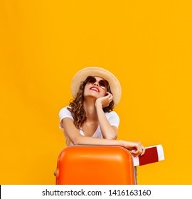 Concept Of Travel. Happy Woman Girl With Suitcase And Passport On  Yellow Colored Background
