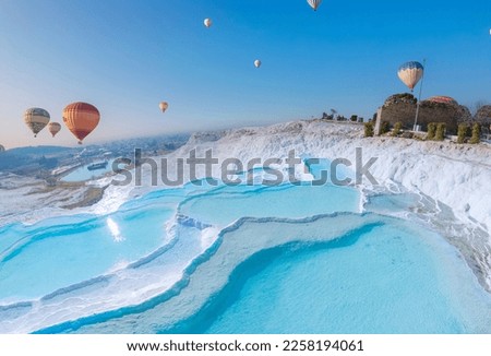 Concept Travel Pamukkale Turkey. Hot air balloon flying Travertine pool and terraces sunset.